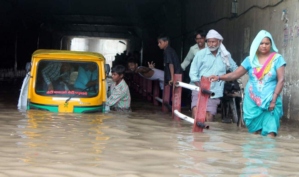 People wade through a water logged road