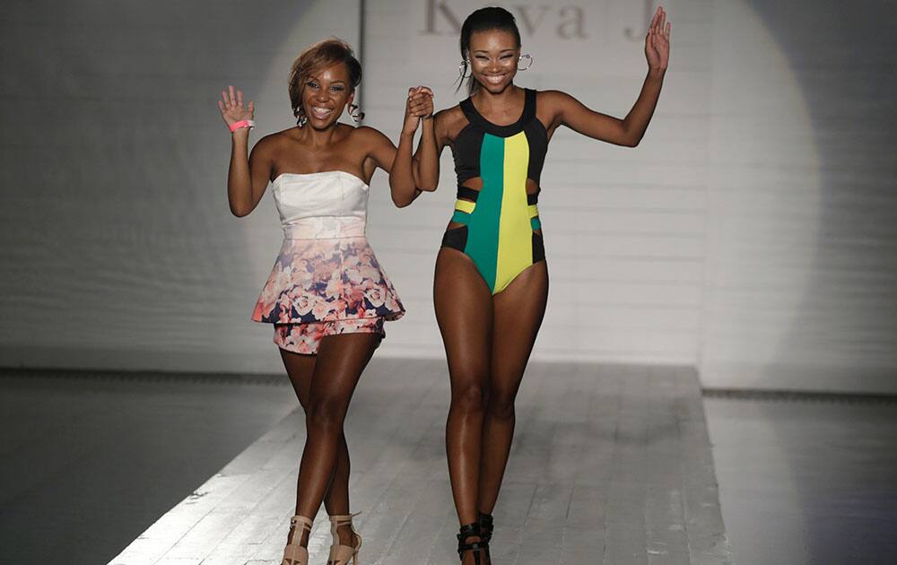 Designer Keva Johnson walks down the runway with a model