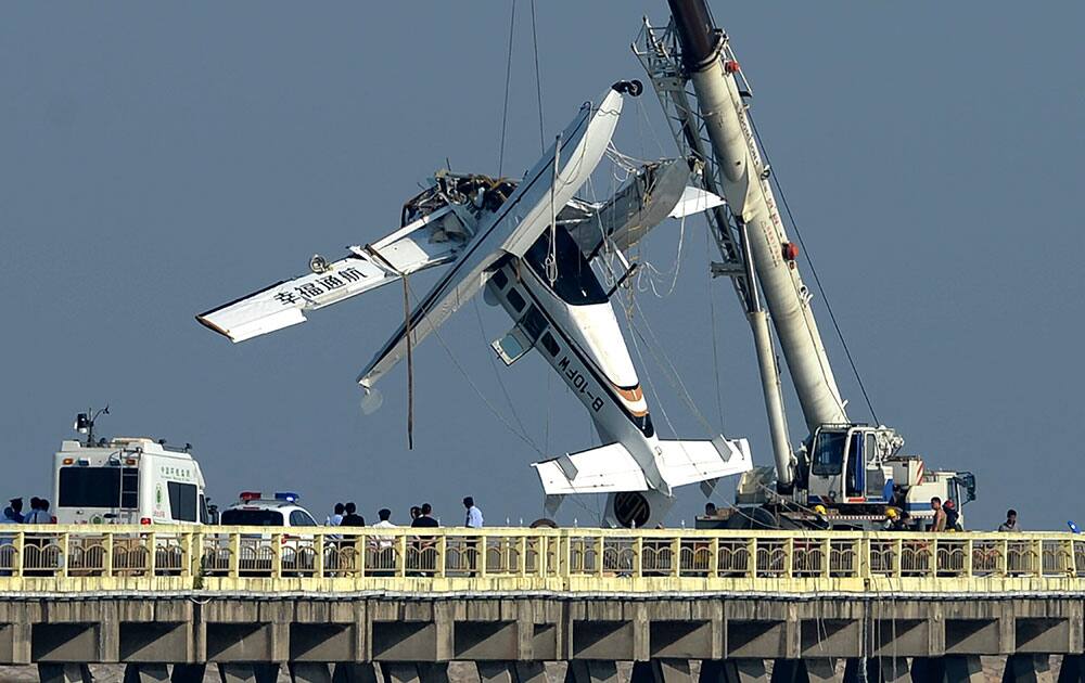 A damaged seaplane is lifted from the pier in Shanghai