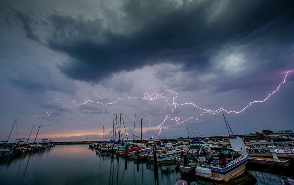 Lightning streaks across the sky over the marina, in Port Washington, Wis.