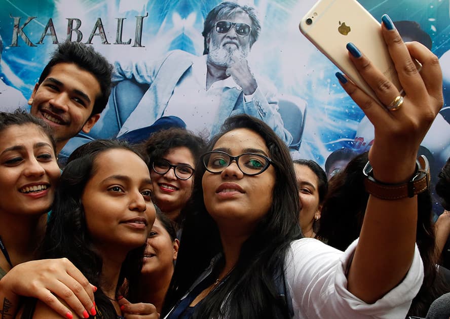 Fans take selfie with the poster of actor Rajinikanth's latest film 'Kabali' in Mumbai.
