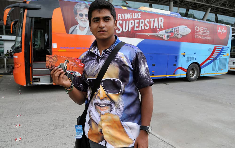 Vignesh Shakti, 18, a fan of superstar Rajinikanth poses with a boarding pass of Malaysia-based AirAsia