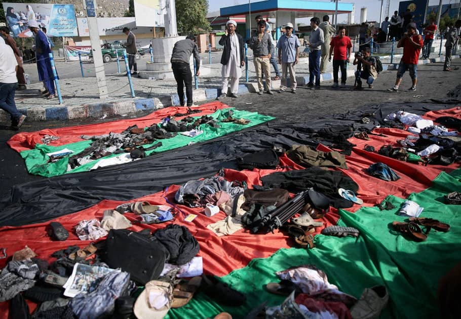 Afghans look at property left behind by victims