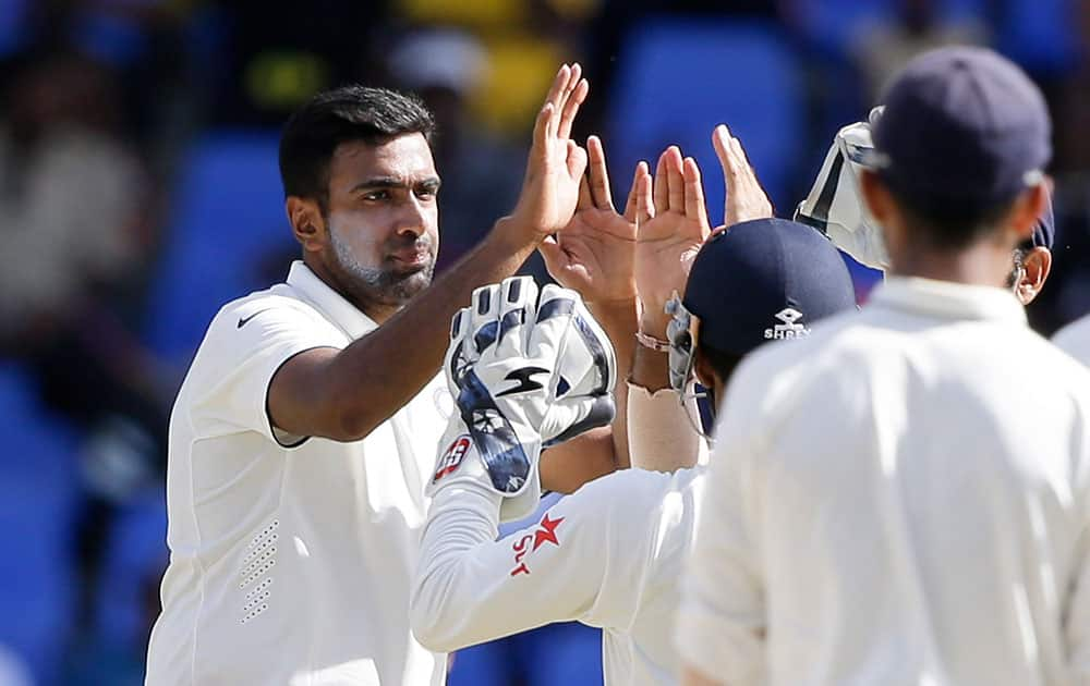 Ravichandran Ashwin  is congratulated by teammates after dismissing Devendra Bishoo