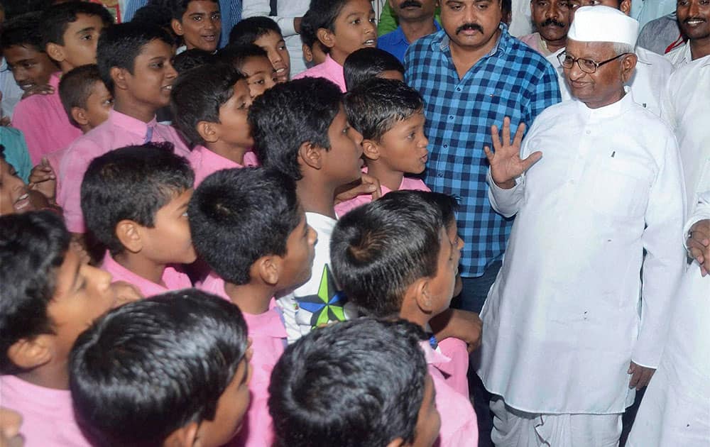 Social worker Anna Hazare interacts students as he visits Vidhan Bhavan 
