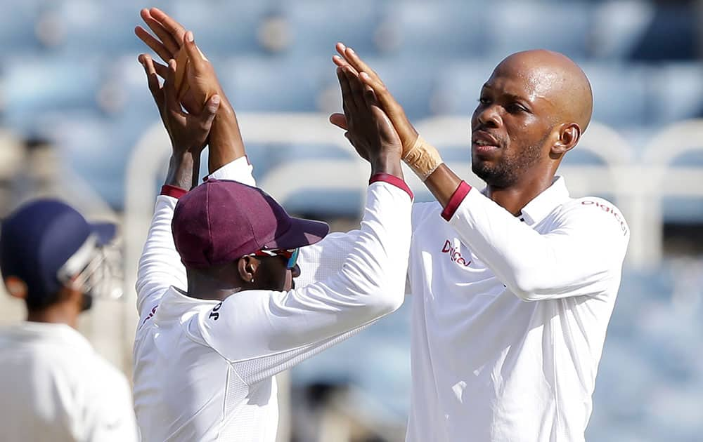 Roston Chase celebrates with teammate Jermaine Blackwood taking the wicket of India's captain Virat Kohli