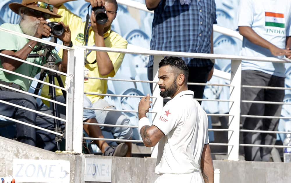 Virat Kohli leaves the pitch after he was dismissed