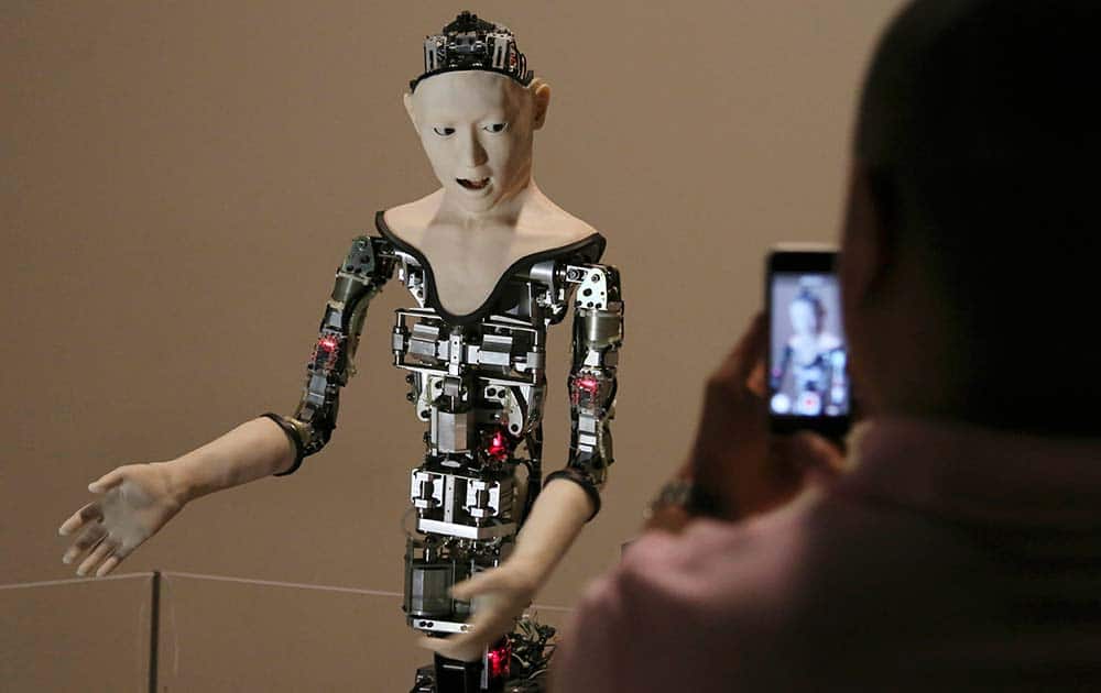 A visitor takes photos of the humanoid robot 'Alter' 