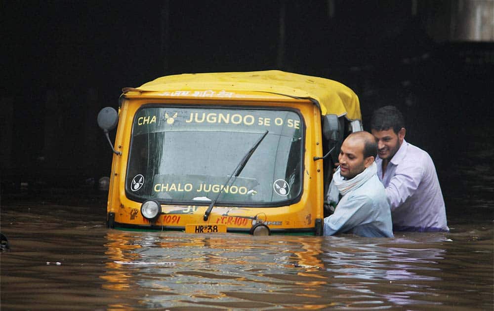 Two men pushing an autorickshaw Two men pushing an autorickshaw