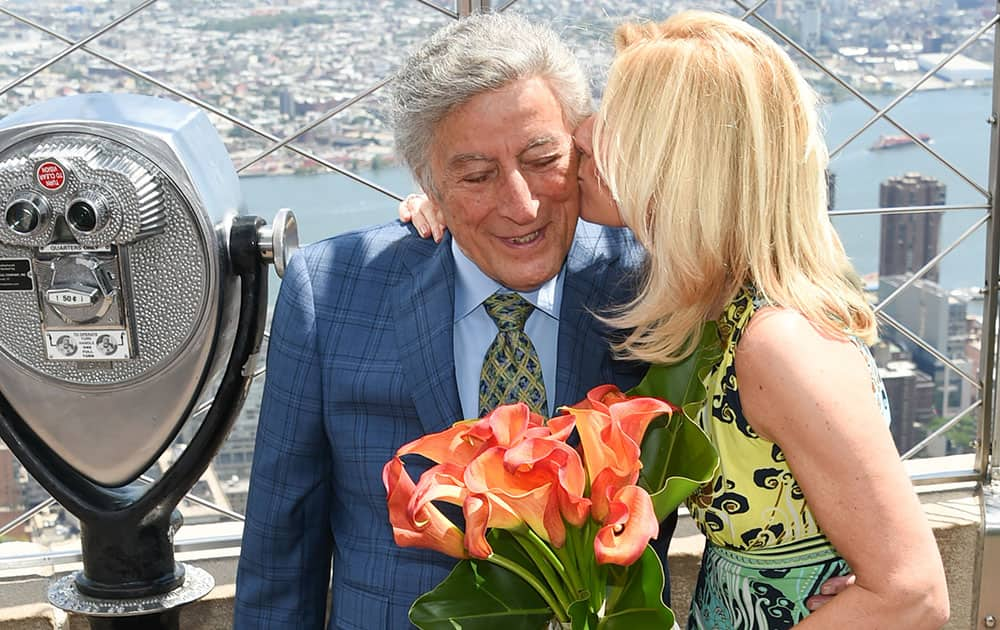 Singer Tony Bennett gets a kiss from his wife Susan Crow on the 86th floor observatory after lighting the Empire State Building in honor of his 90th birthday