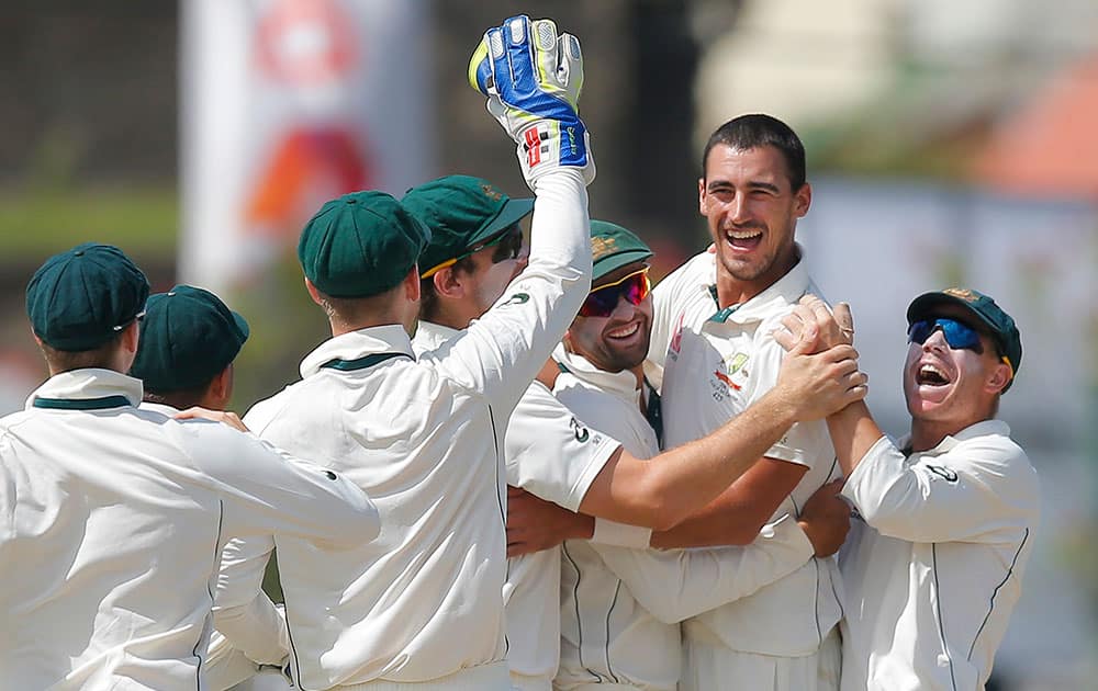 Australia's Mitchell Starc celebrates with team mates after taking the wicket of Sri Lanka's Dimuth Karunaratne