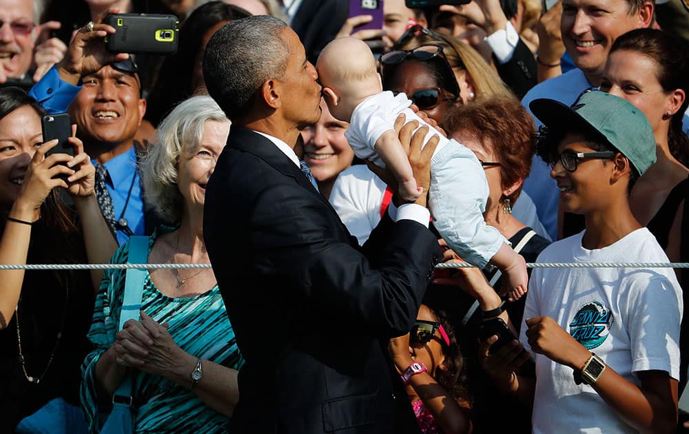 President Barack Obama kisses a infant during a state arrival ceremony for Singapore's Prime Minister Lee Hsien Loong