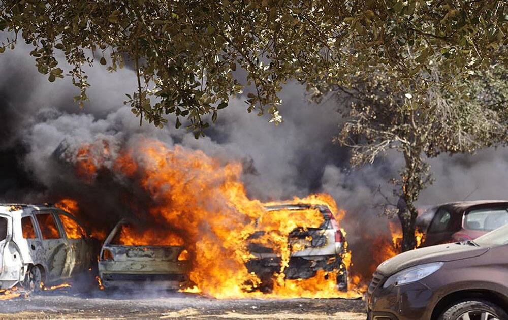 Cars burn in a parking lot in Barragem da Povoa eastern Portugal