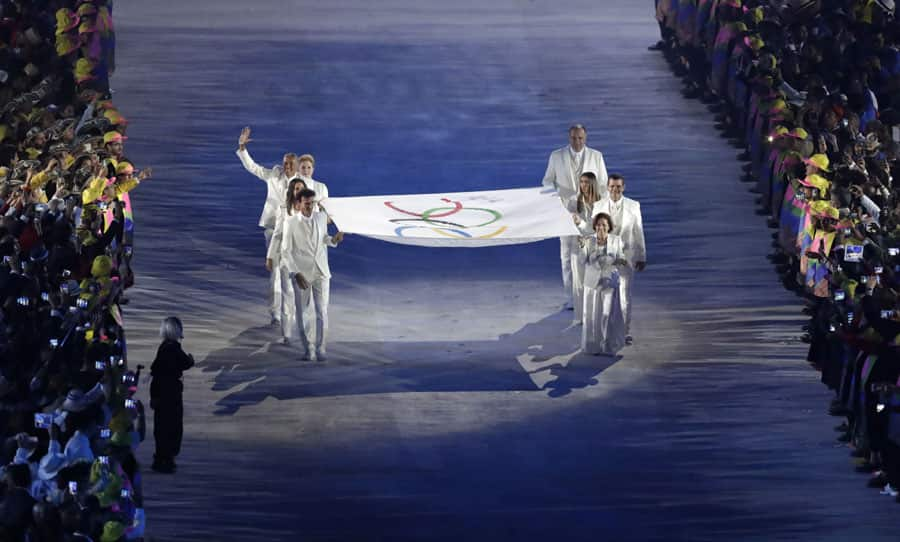 The Olympic flag is carried into the stadium during