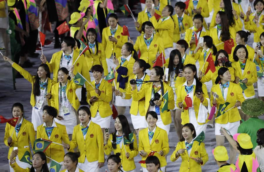 Chinese athletes hold Chinese and Brazilian flags