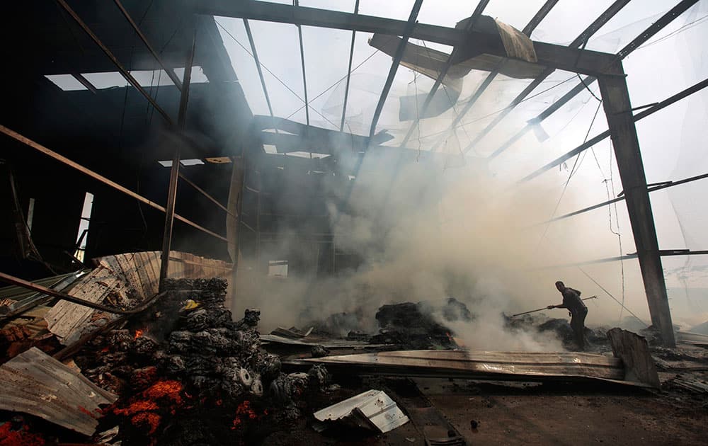 A worker loks for survivors amid the rubble of a food factory that was hit by Saudi-led airstrikes, in Sanaa, Yemen