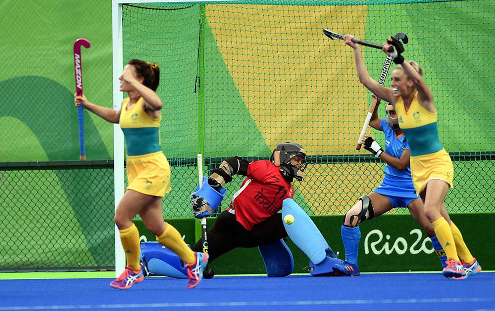 Indias goalkeeper Savita looks on as Australias players celebrate their goal