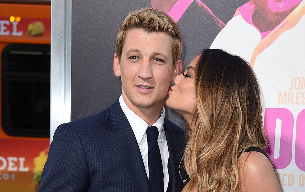 Keleigh Sperry, right, kisses Miles Teller as they arrive at the Los Angeles premiere of 