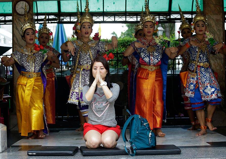 A visitor prays as Thai