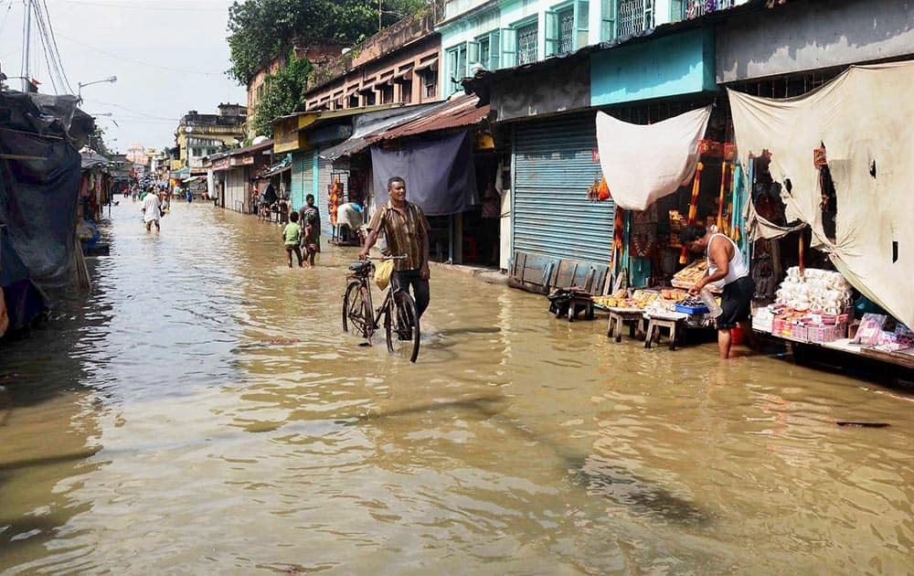 Locals wade through a water logged road