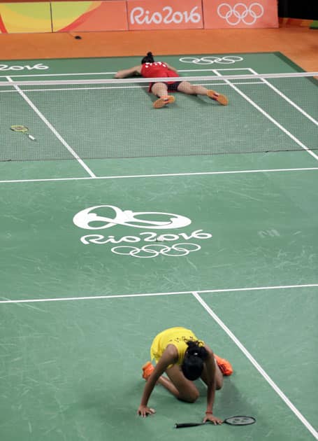 Spain's Carolina Marin, top, lies on the court