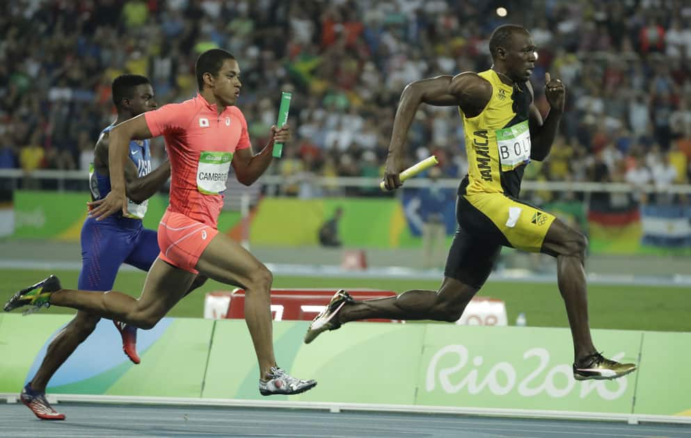 Usain Bolt, right, competes in the men's 4x100-meter