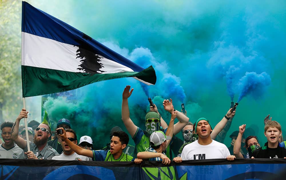 Members of the Emerald City Supporters set off smoke effects and sing as they take part in the traditional March to the Match before an MLS soccer match