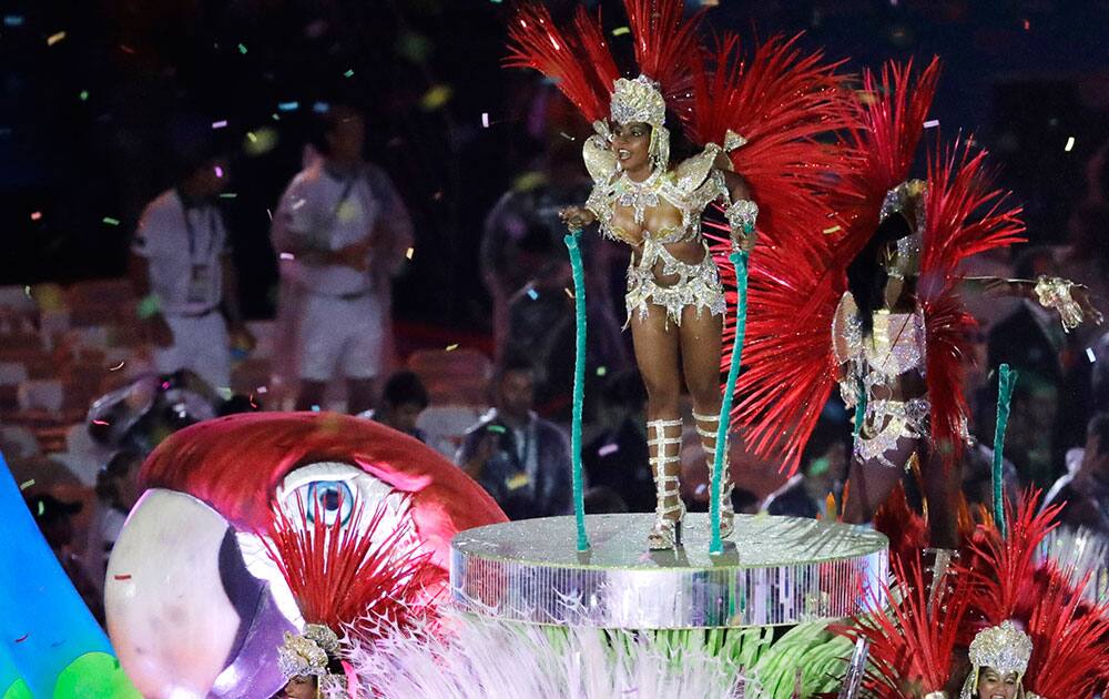 Plumed performers participate in the closing ceremony in the Maracana stadium