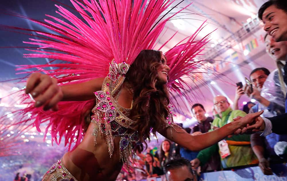 An artist meets with athletes during the closing ceremony