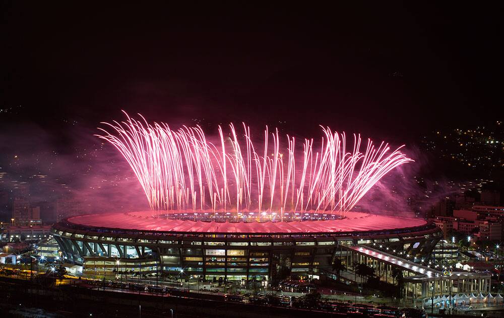 People watch from the Mangueira slum fireworks exploding above the Maracana stadium during the closing ceremony for the Summer Olympics in Rio de Janeiro, Brazil