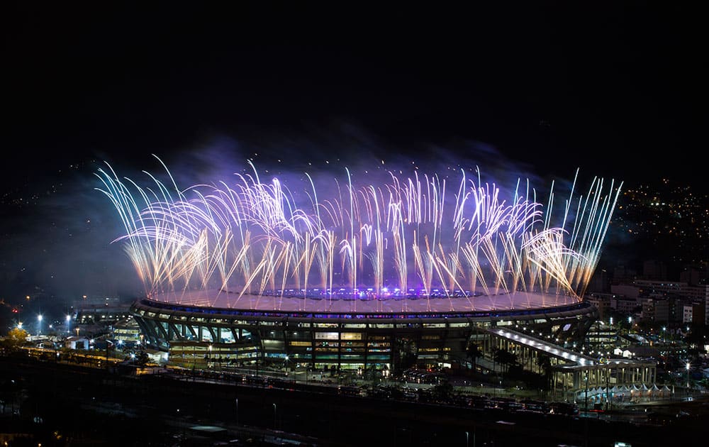 People watch from the Mangueira slum fireworks exploding above the Maracana stadium during the closing ceremony for the Summer Olympics in Rio de Janeiro, Brazil