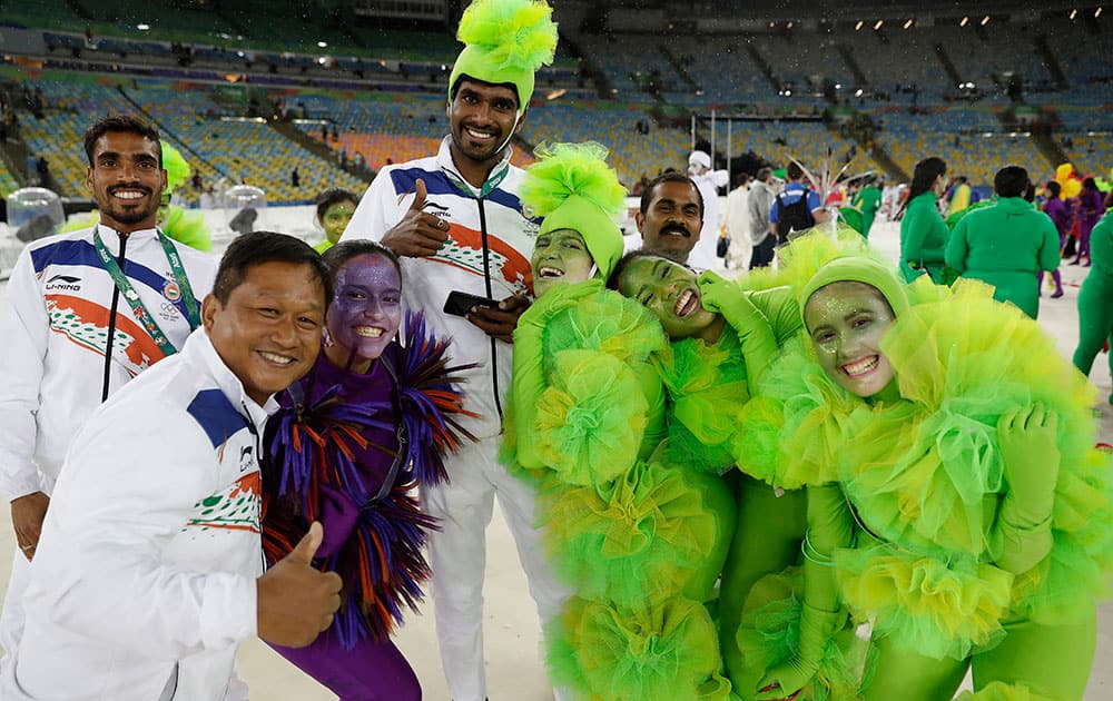 Athletes pose for picture with performers during the closing ceremony