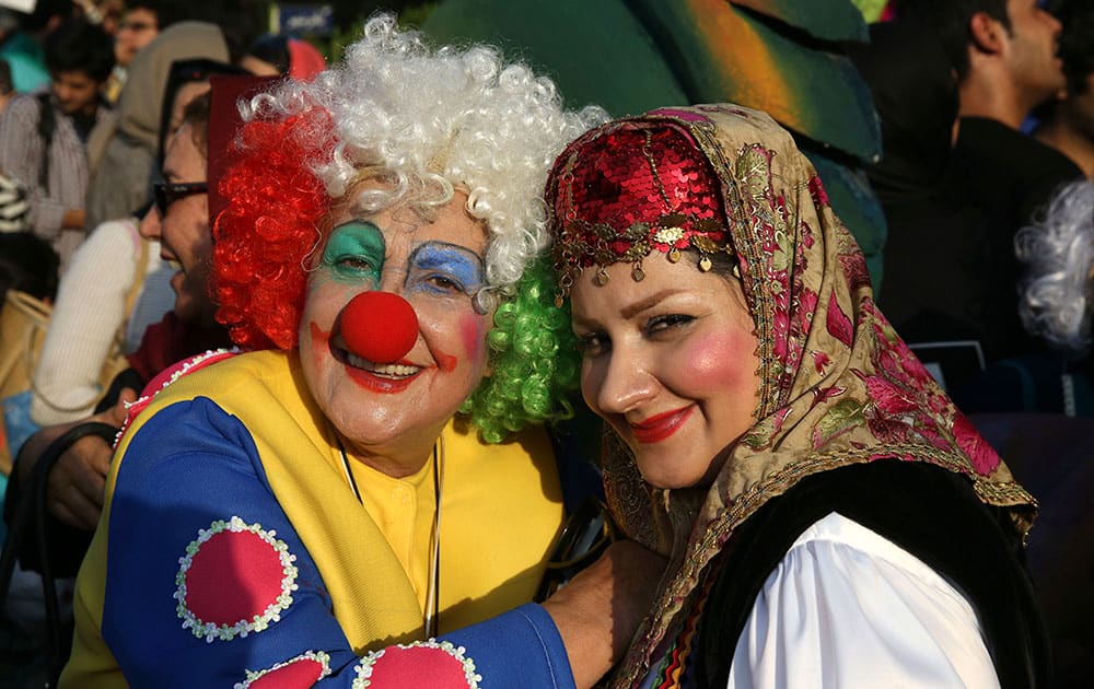 Iranian actresses Parivash Ghaem Maghami, left, dressed as a clown and Amina Hajiabadi with a traditional costume pose for a photo in a carnival during inauguration of Tehran-Mobarak 16th International Puppet Festival