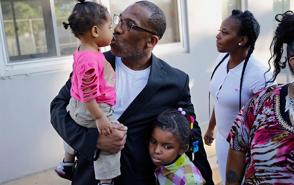 Anthony Wright gets a kiss from his granddaughter Romera Wright, 1, and holds on tight to his other granddaughter, Daria Wright, 8, while spending time with his family after walking out of Curran Fromhold Correctional Facility a free man in Philadelphia