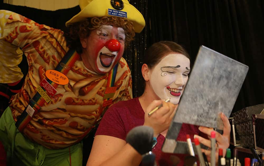 David Mc Cullough, also known as Korn Pop the clown, of Chandler, Texas, looks over the shoulder of Rebecca Andrews, of Forsyth, Georgia