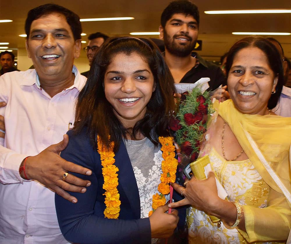 Sakshi Malik being greeted by her family members as she arrives at IGI airport T3