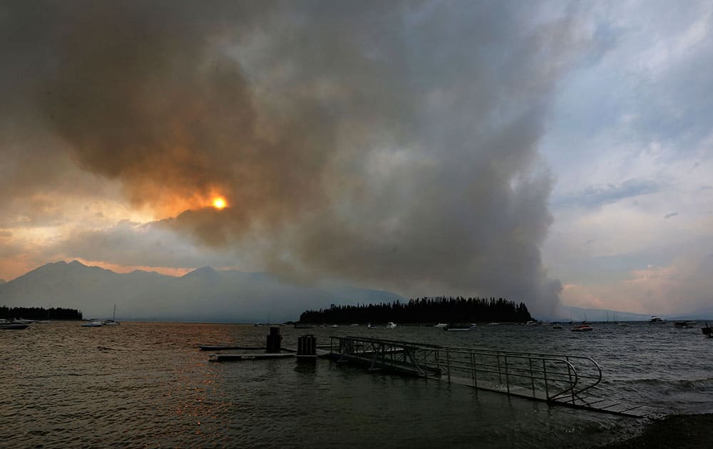 A wildfire is visible from Leek's Marina on the shore of Jackson Lake, in north Grand Teton National Park
