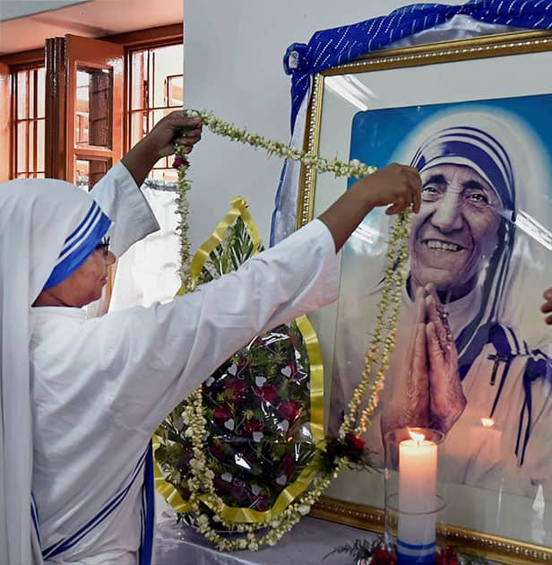 A nun garlands Mother Teresas statue on the occaasion of her 106th birth anniversary, in Kolkata