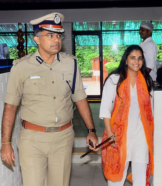 City police commissioner N Chandrasekhar escorts Kannada actor and Congress member Ramya as she comes out of a hotel after attending a discussion