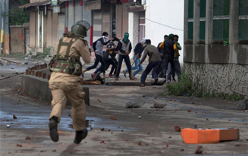 A security jawan chasing away protesters during a clash in Srinagar A security jawan chasing away protesters during a clash in Srinagar