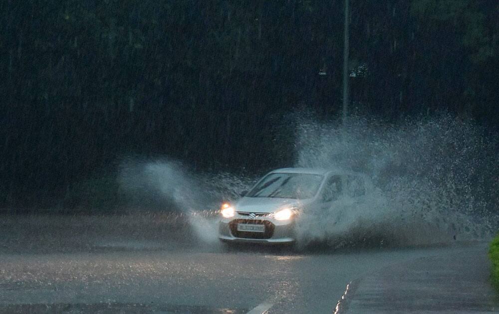 A vehicle sprays water as it passes through the water logged roads after heavy rains in New Delhi A vehicle sprays water as it passes through the water logged roads after heavy rains in New Delhi