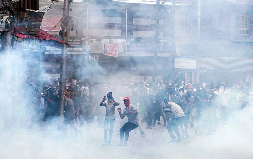 Protesters throwing stones at police amid heavy tear smoke during a clash in Srinagar Protesters throwing stones at police amid heavy tear smoke during a clash in Srinagar