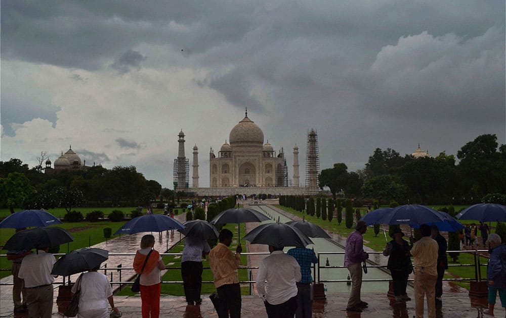 Visitors holding umbrellas during rains at the Taj Mahal Visitors holding umbrellas during rains at the Taj Mahal