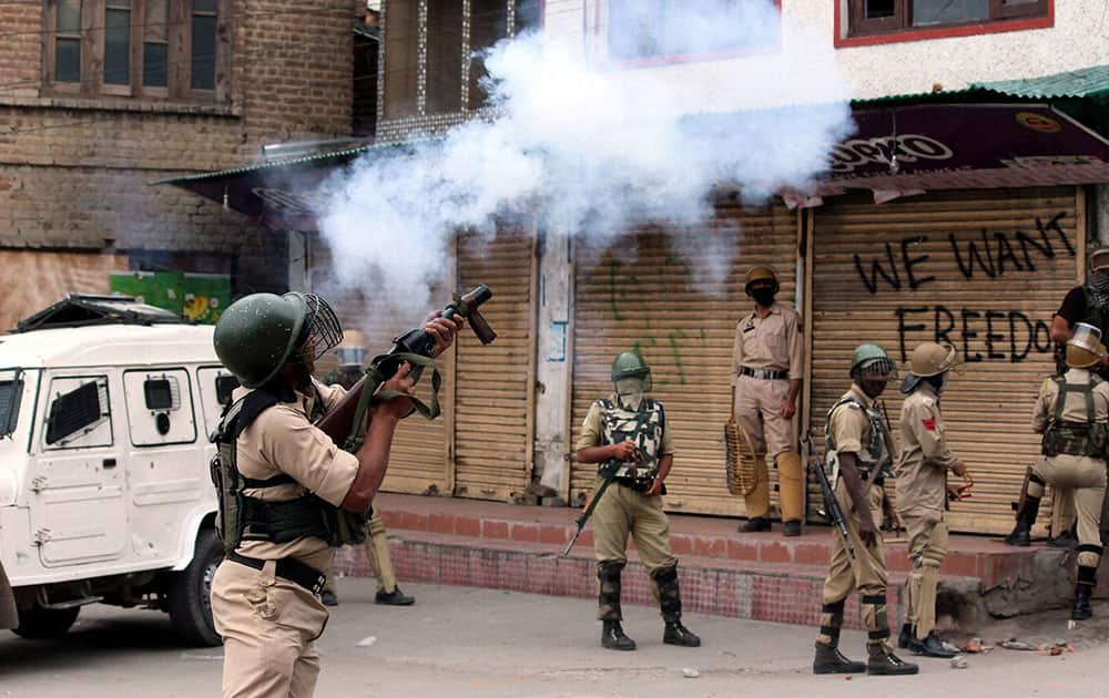 Security jawans fire tear gas shells to disperse protesters who staged a protest march towards Lal Chowk