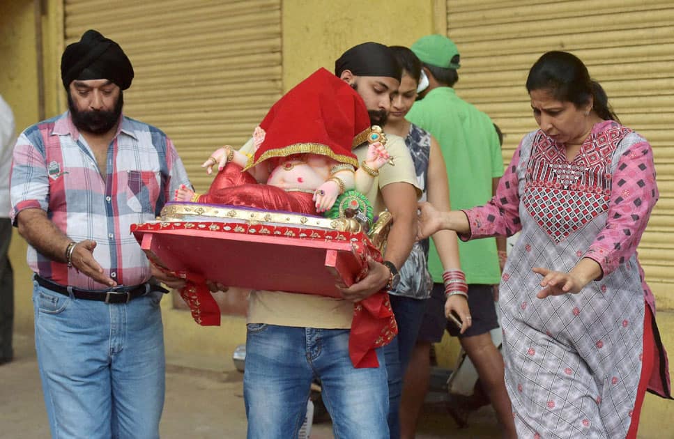 Punjabi community carries an idol of Lord Ganesh