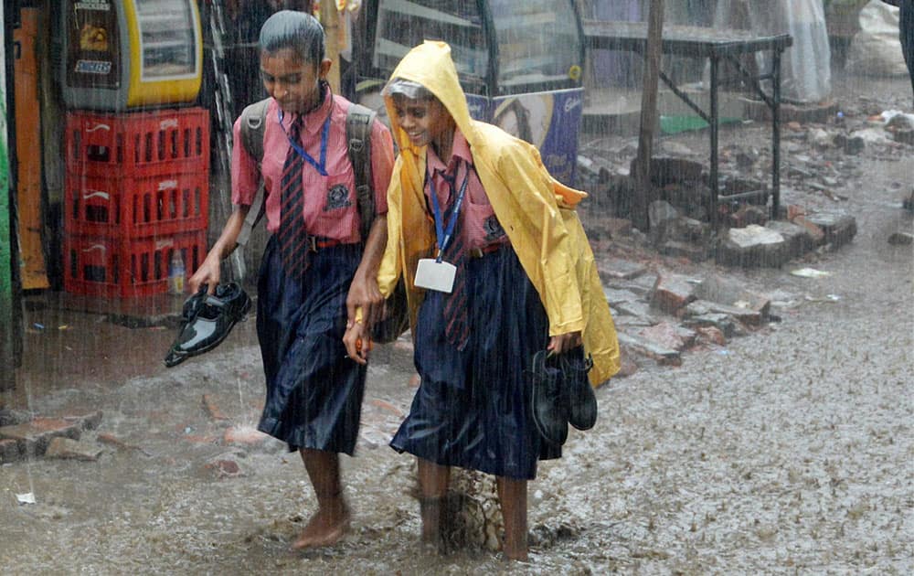 School children walk in rains in Patna