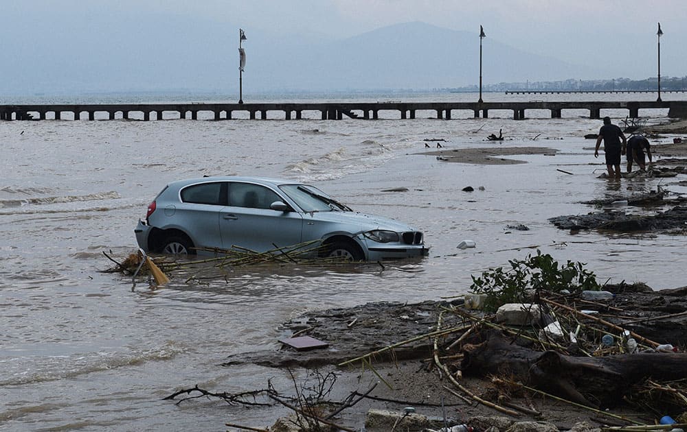 A car is abandoned in the sea in Agia Triada village about 20 kilometers from the city of Thessaloniki, northern Greece, after heavy overnight rain