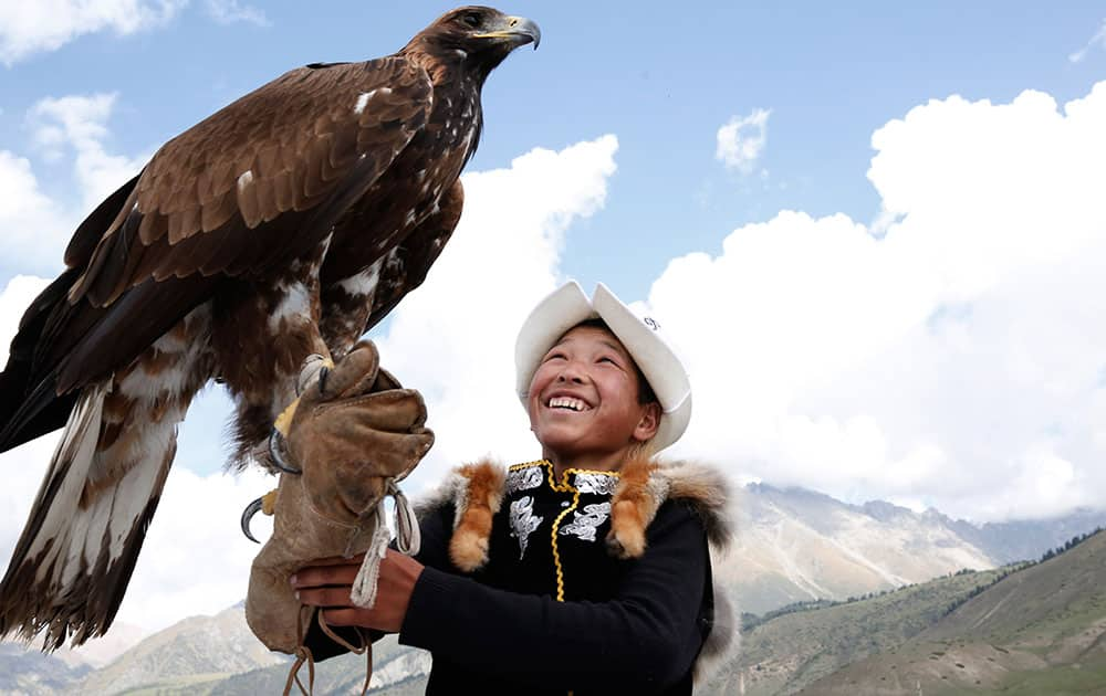 A boy handles an eagle at the World Nomad Games