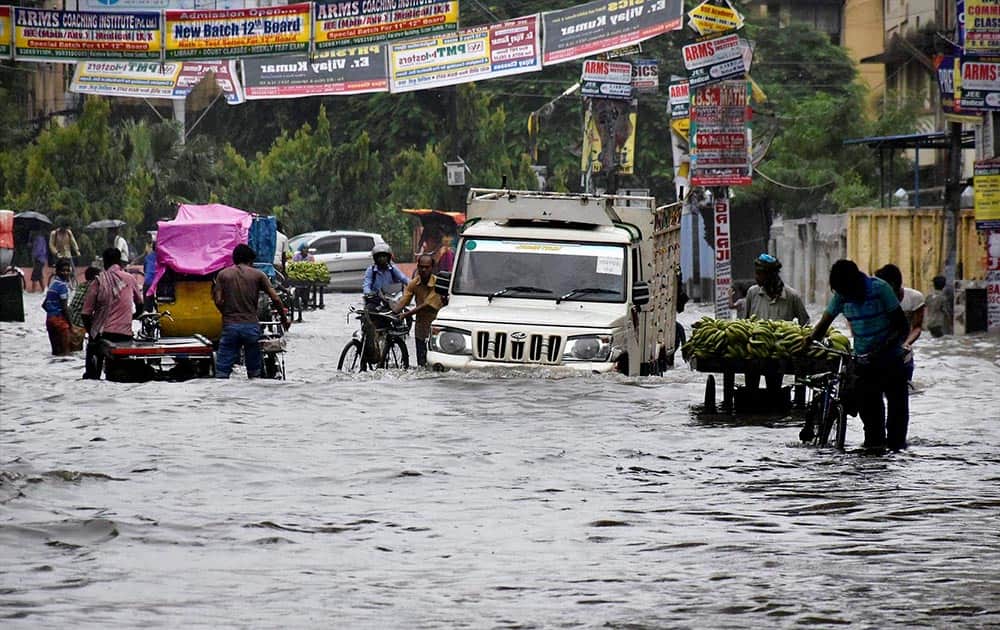 People wade through submerged streets after heavy rain in Patna.