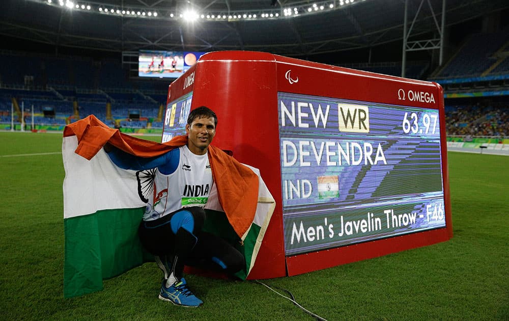 Devendra Jhajharia poses for the pictures next to the scoreboard that shows his world record